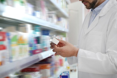 Professional pharmacist with medicine in drugstore, closeup