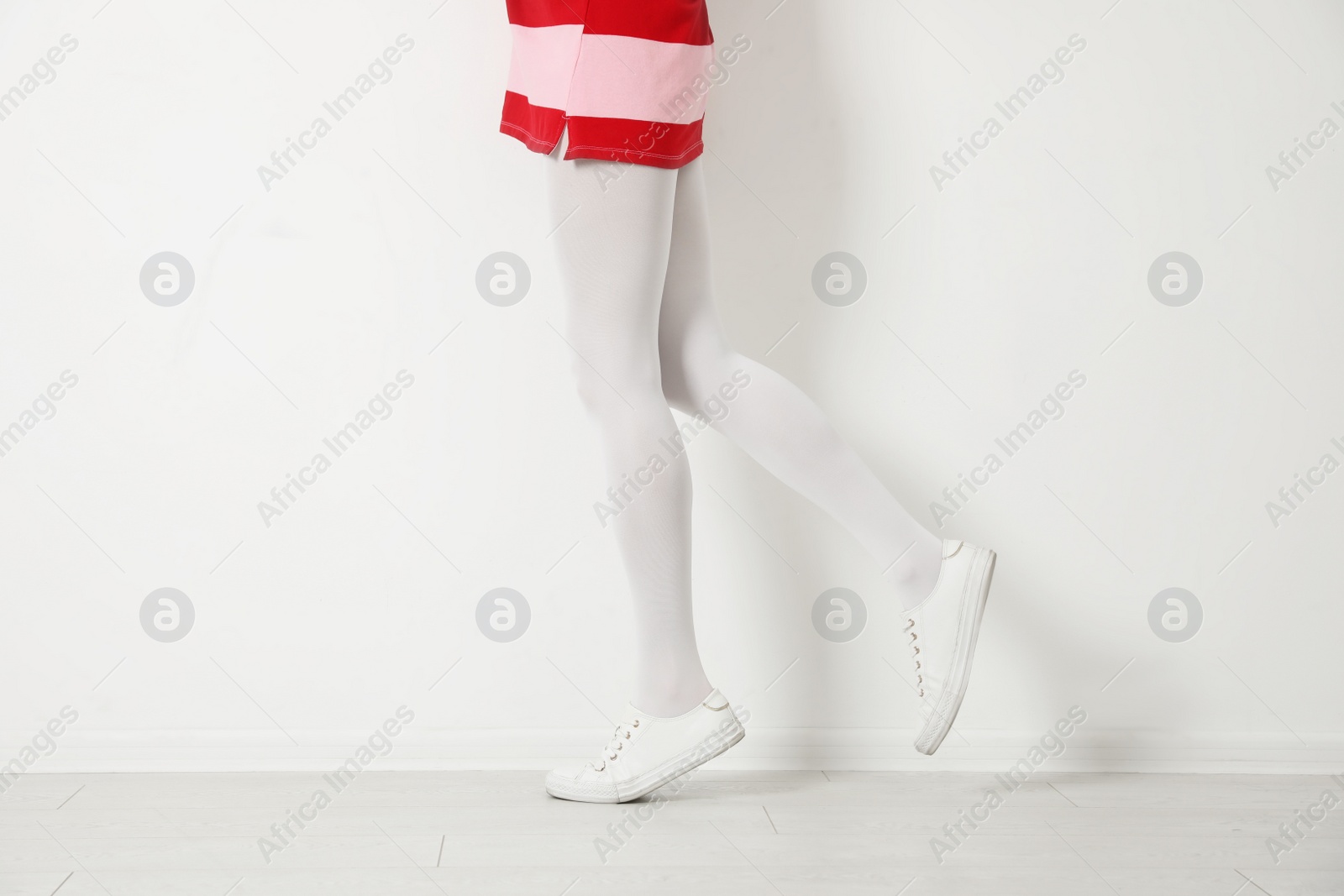 Photo of Woman wearing tights near white wall, closeup