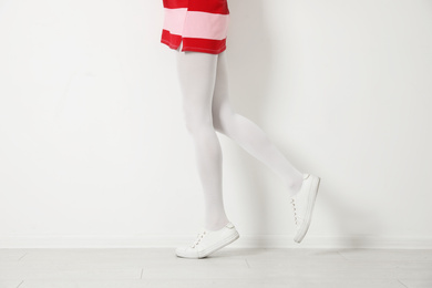 Photo of Woman wearing tights near white wall, closeup