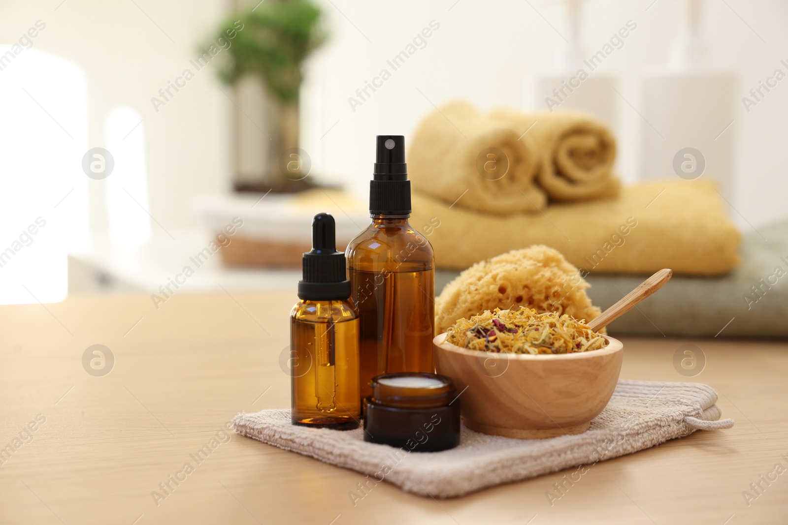 Photo of Dry flowers, bottles of essential oils and jar with cream on wooden table indoors, space for text. Spa time