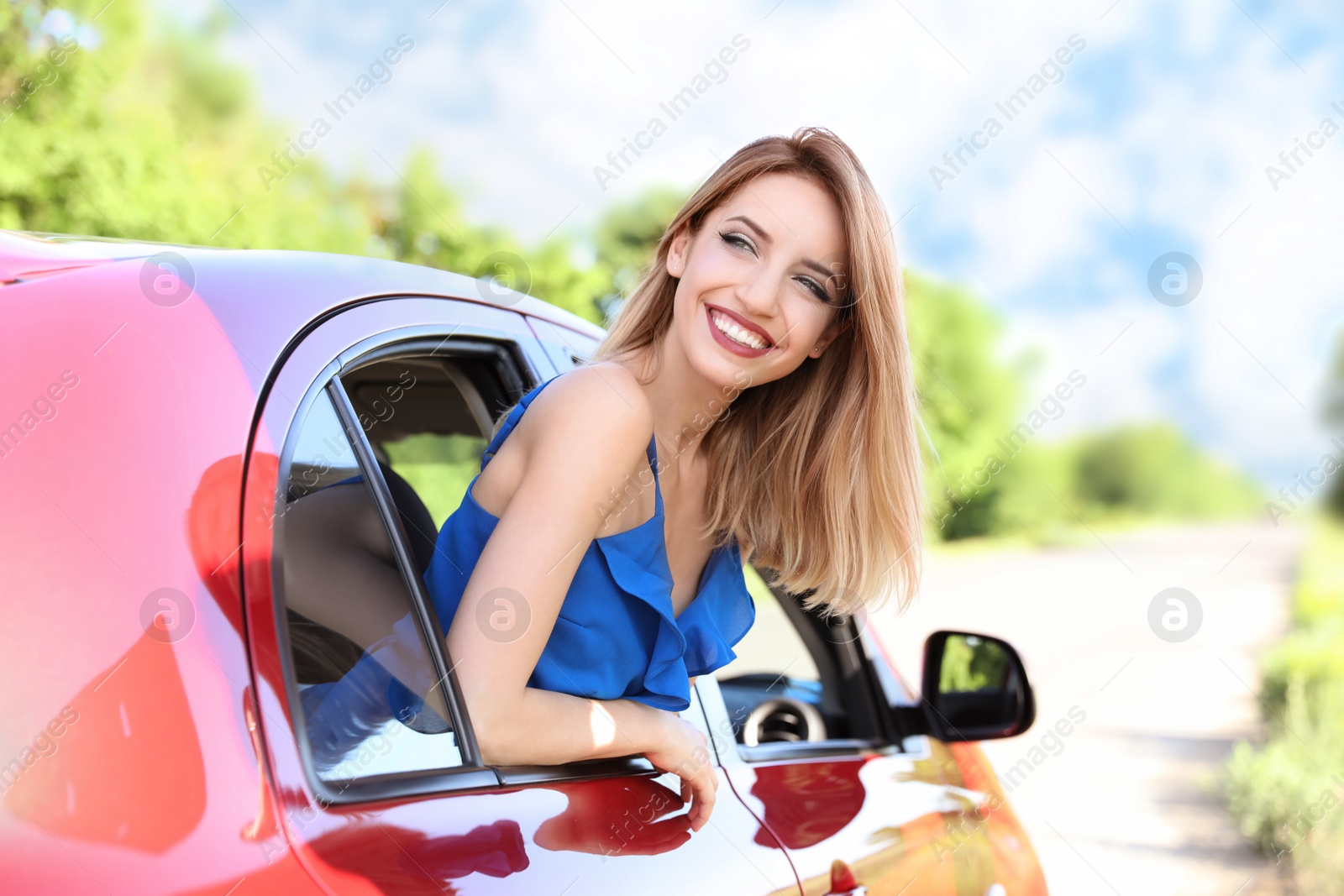 Photo of Happy beautiful young woman in car