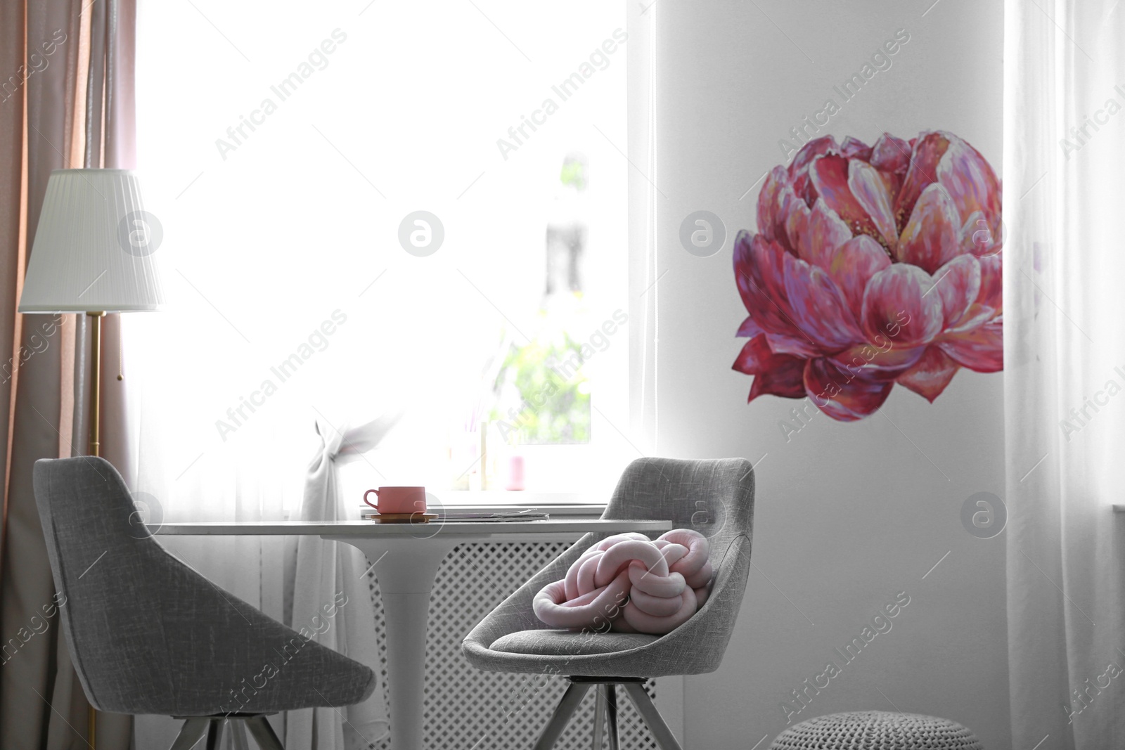 Photo of Stylish room interior with table and chairs near decorated wall