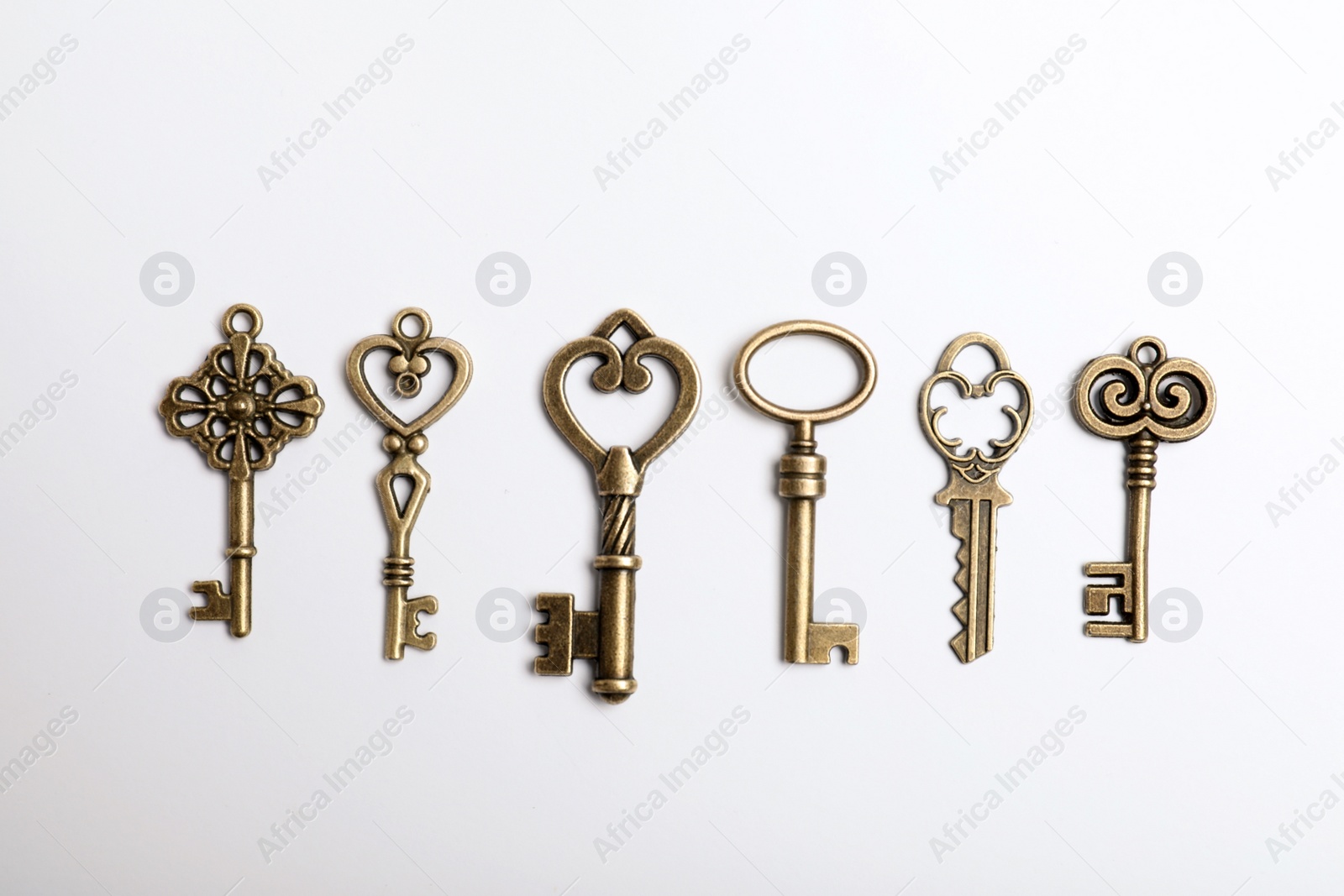 Photo of Bronze vintage ornate keys on white background, top view