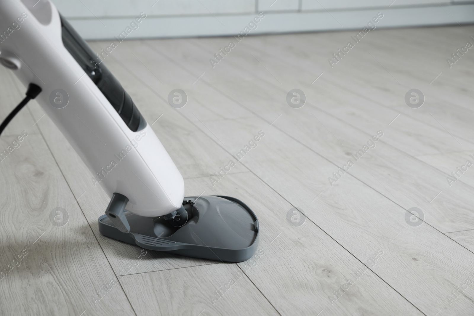 Photo of Cleaning floor with steam mop at home. Space for text