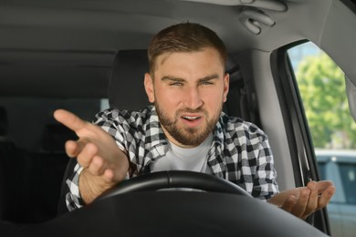 Photo of Emotional man in car. Aggressive driving behavior