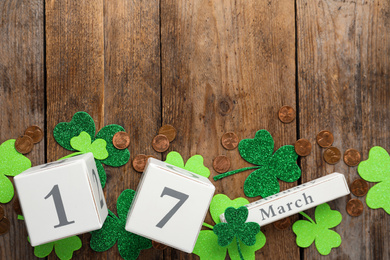 Photo of Flat lay composition with block calendar on wooden background, space for text. St. Patrick's Day celebration