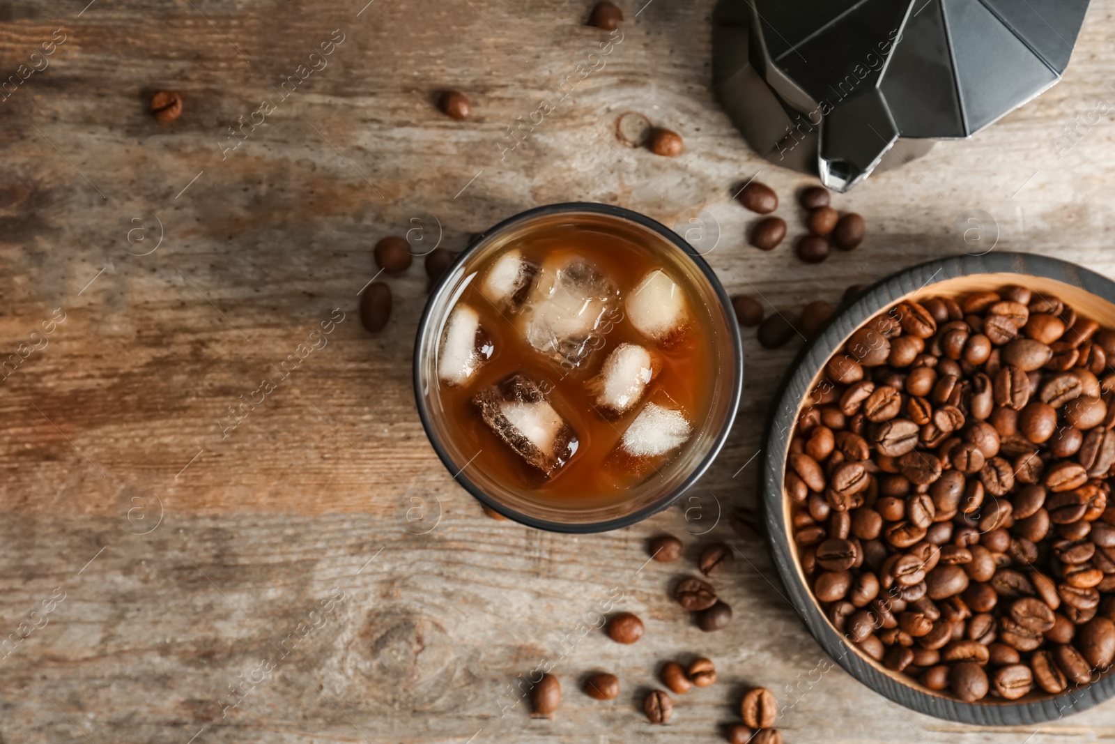 Photo of Glass with cold brew coffee on wooden background, top view