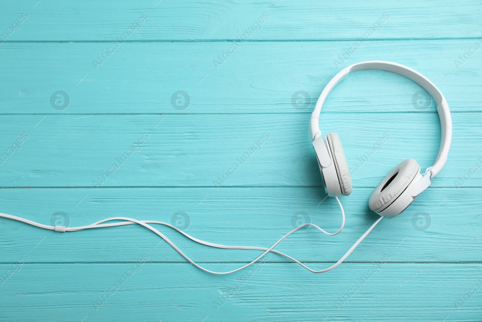 Photo of Stylish modern headphones and space for text on wooden background, top view