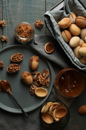 Freshly baked homemade walnut shaped cookies with nuts and boiled condensed milk on wooden table, flat lay