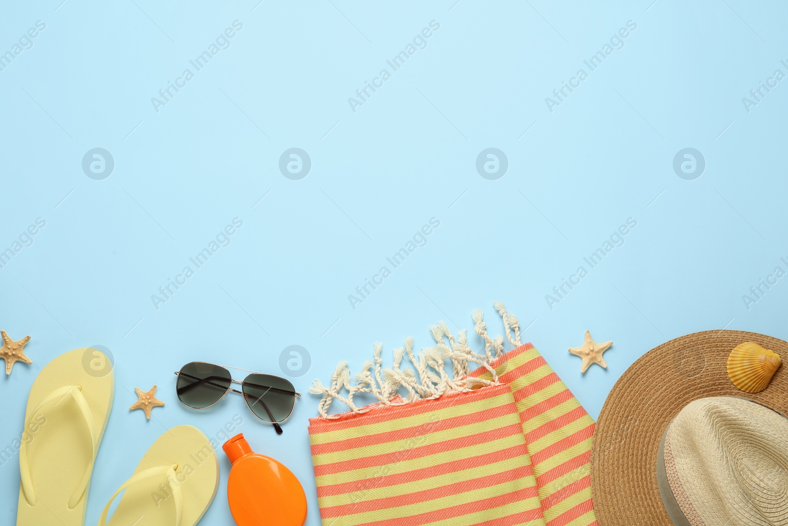 Photo of Flat lay composition with different beach objects on light blue background, space for text