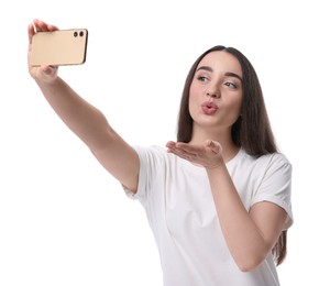 Photo of Young woman taking selfie with smartphone and blowing kiss on white background