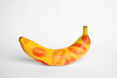 Photo of Fresh banana with red lipstick marks on white background. Oral sex concept