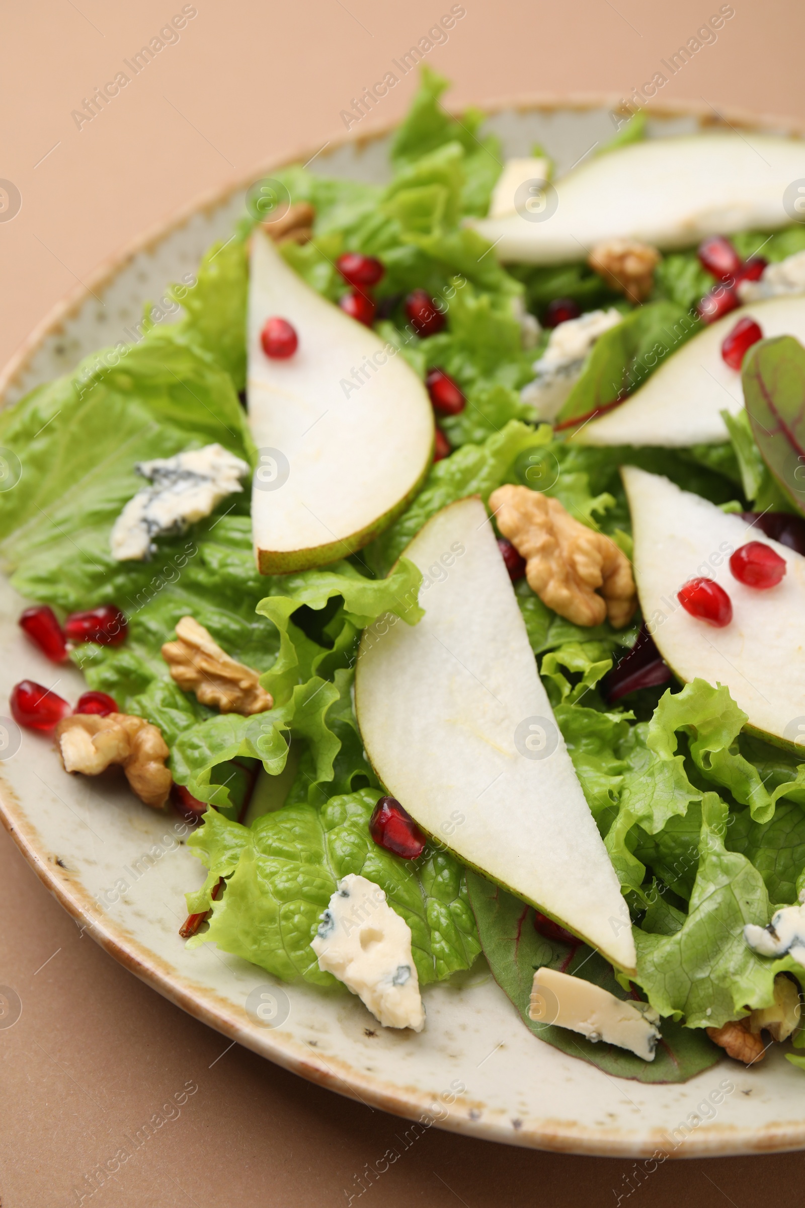 Photo of Delicious pear salad on beige background, closeup