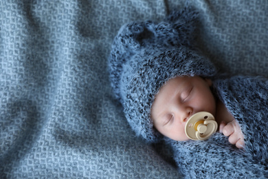 Photo of Cute newborn baby sleeping on blanket, top view. Space for text
