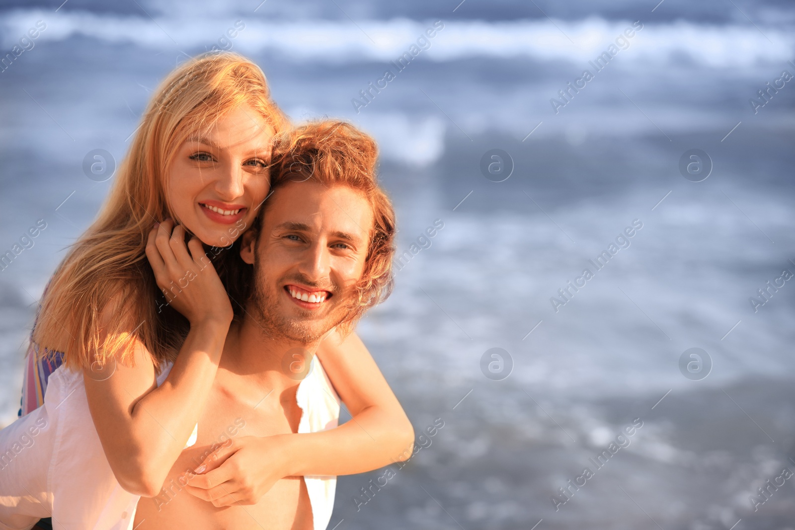 Photo of Young lovely couple on beach at sunset