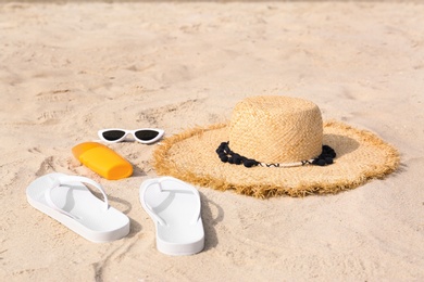 Photo of Set of different stylish beach accessories on sand