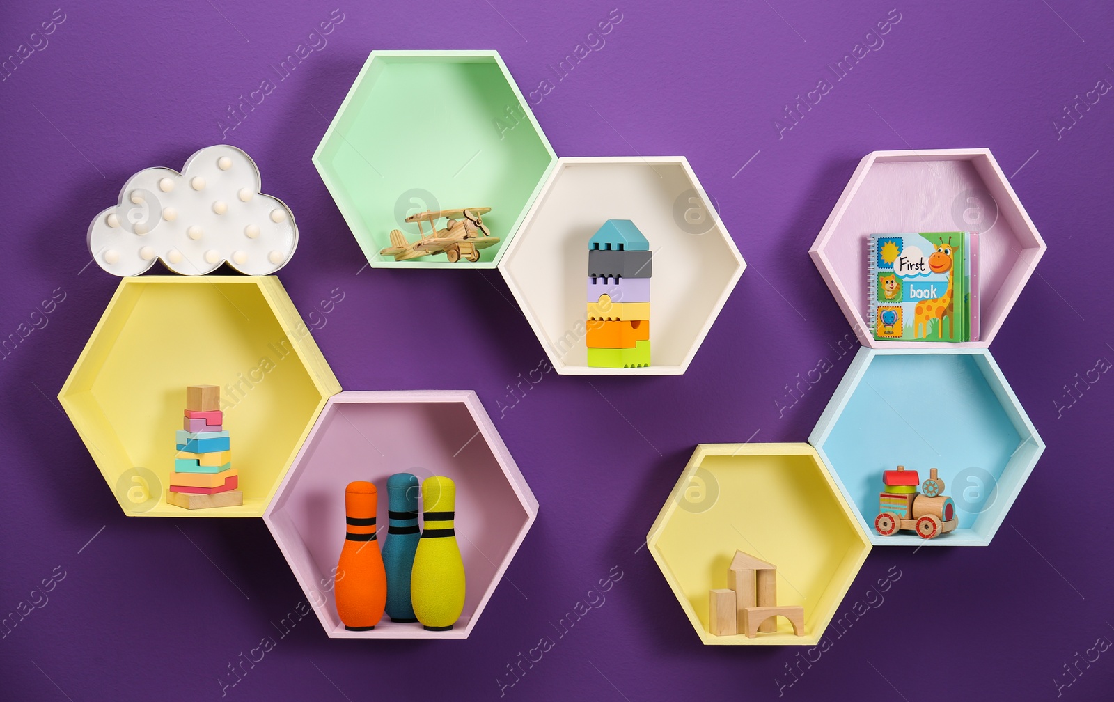 Photo of Hexagon shaped shelves with toys on purple wall. Interior design