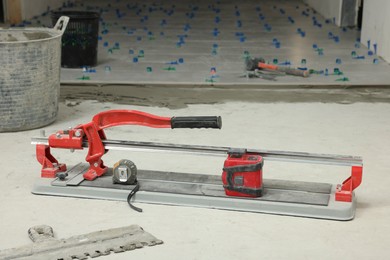 Tile cutter and tools on floor indoors