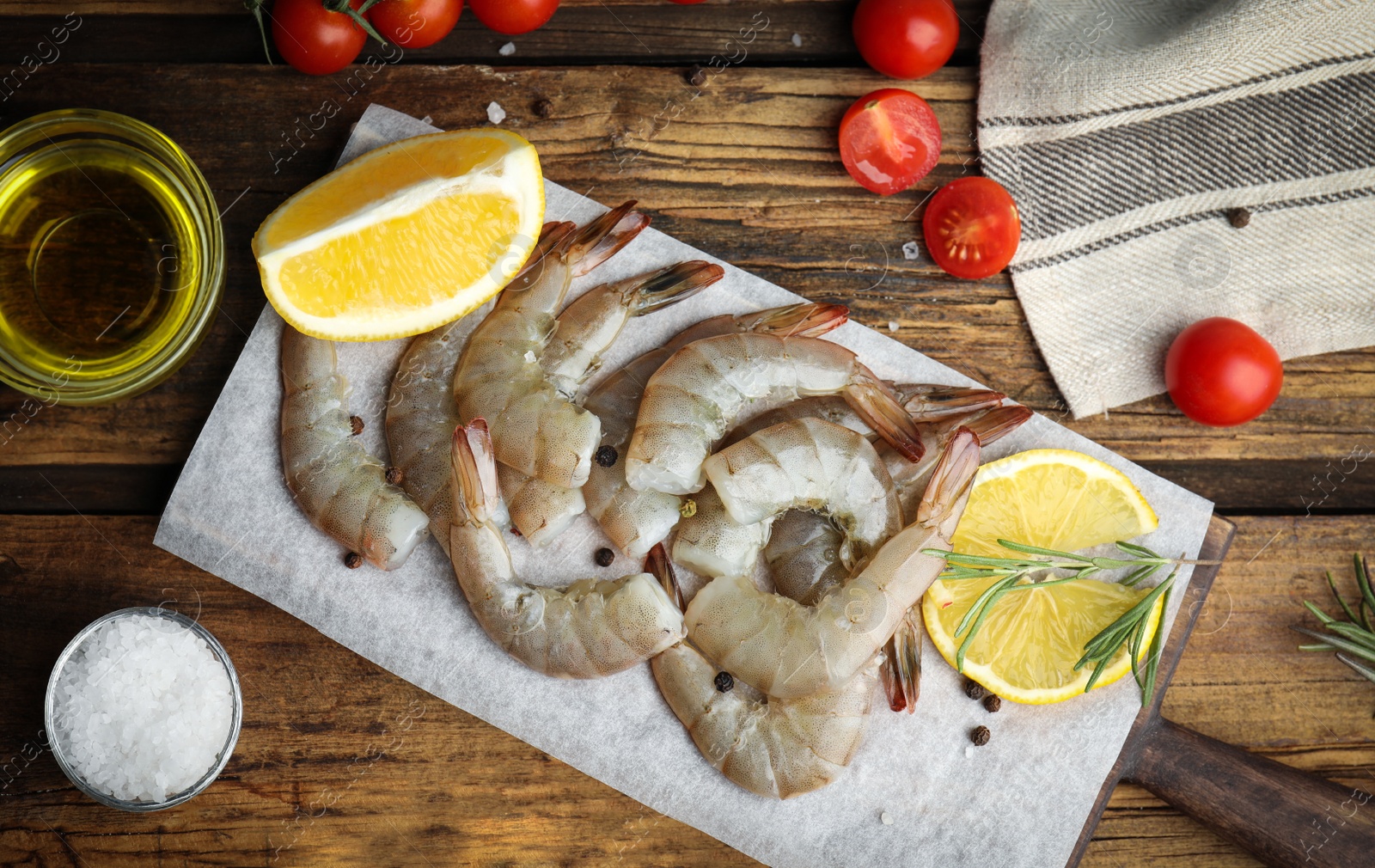 Photo of Flat lay composition with fresh raw shrimps on wooden table