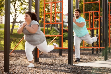 Photo of Overweight couple training together on sports ground