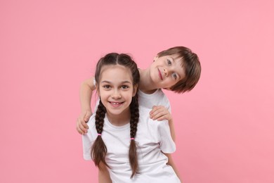 Photo of Happy brother and sister on pink background