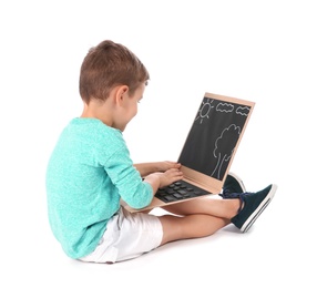 Little child playing with carton laptop on white background. Indoor entertainment