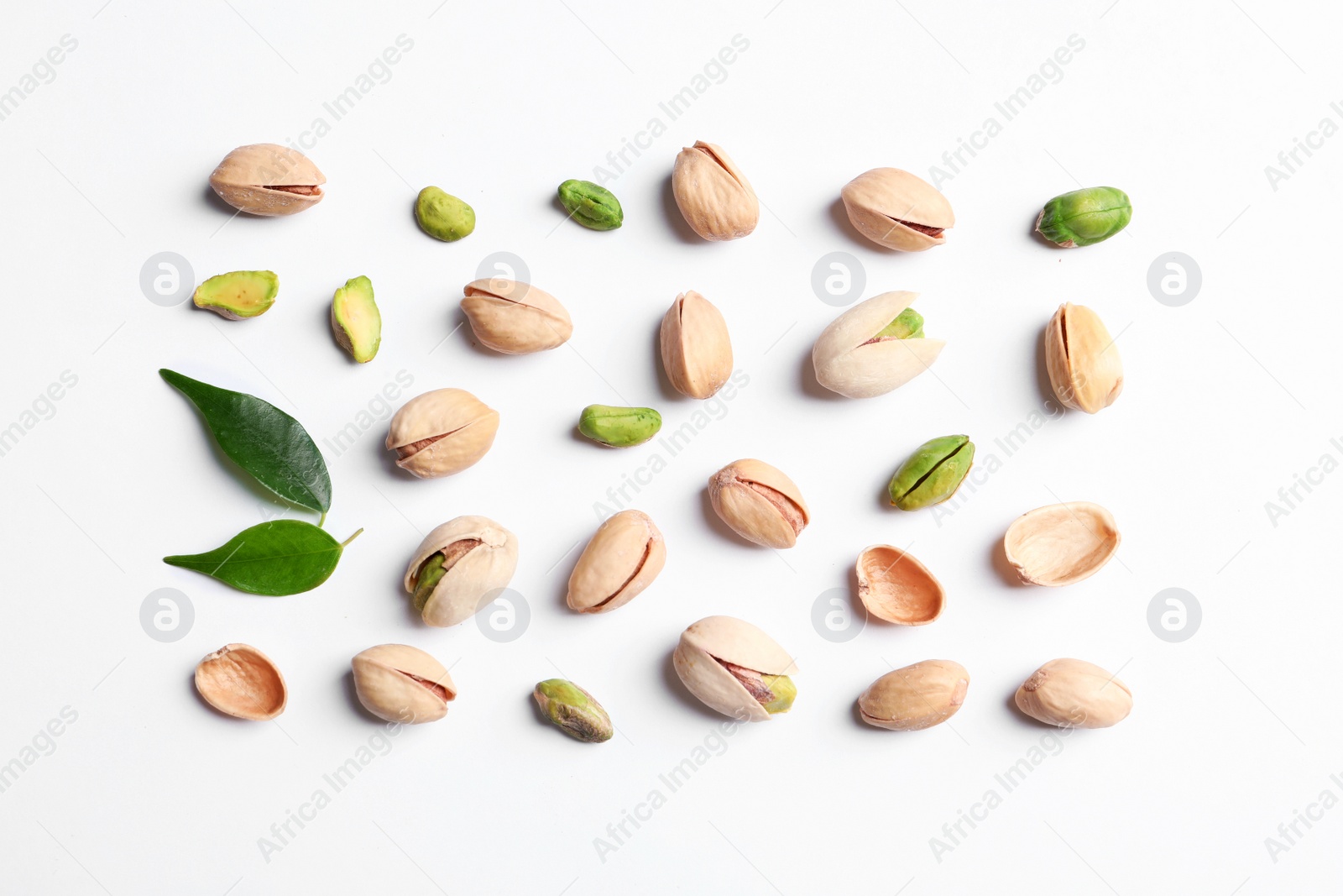 Photo of Organic pistachio nuts on white background, flat lay