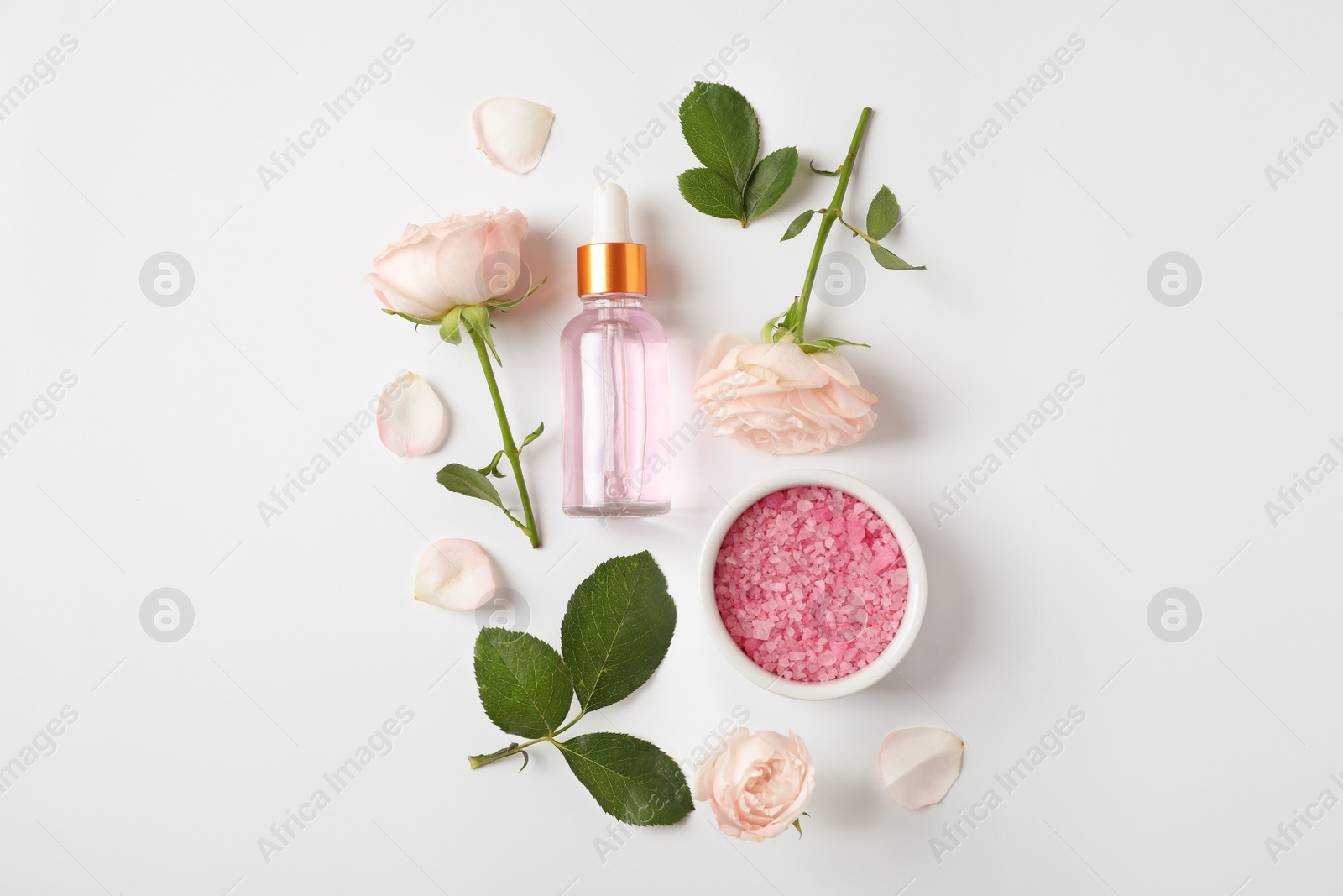 Photo of Composition with rose essential oil on white background, top view