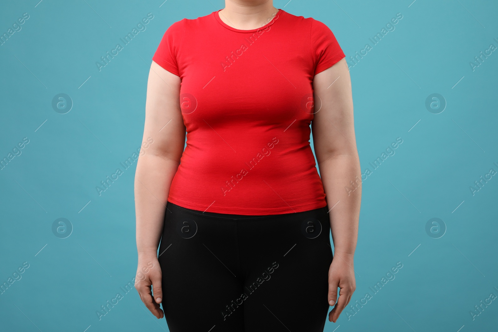 Photo of Overweight woman on light blue background, closeup