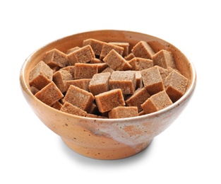 Photo of Bowl with cubes of brown sugar on white background