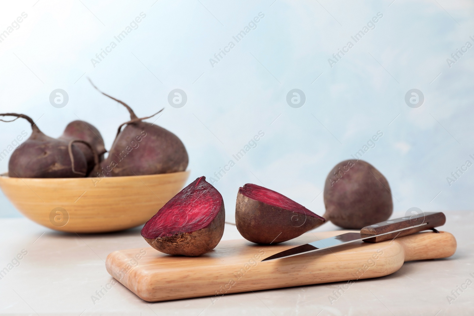 Photo of Wooden board with ripe beets on table