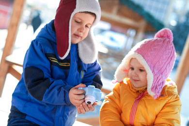 Photo of Cute children with toy camera outdoors. Future photographers