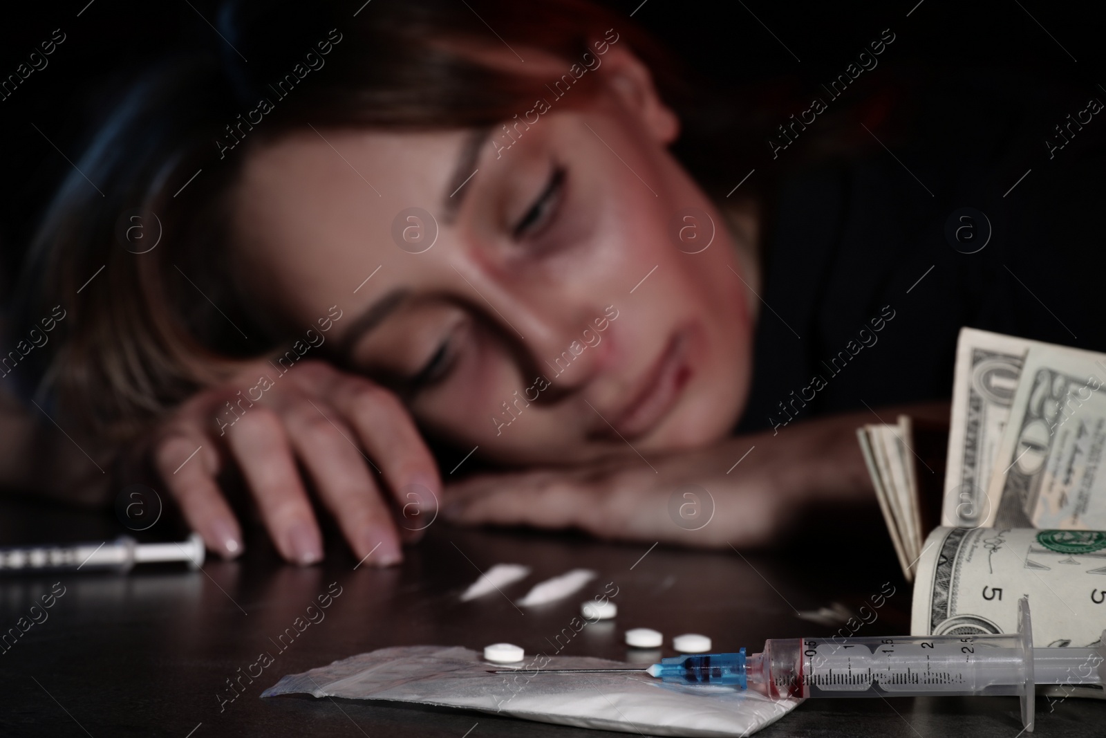 Photo of Addicted woman at table, focus on different drugs