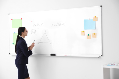 Young teacher near whiteboard in modern classroom