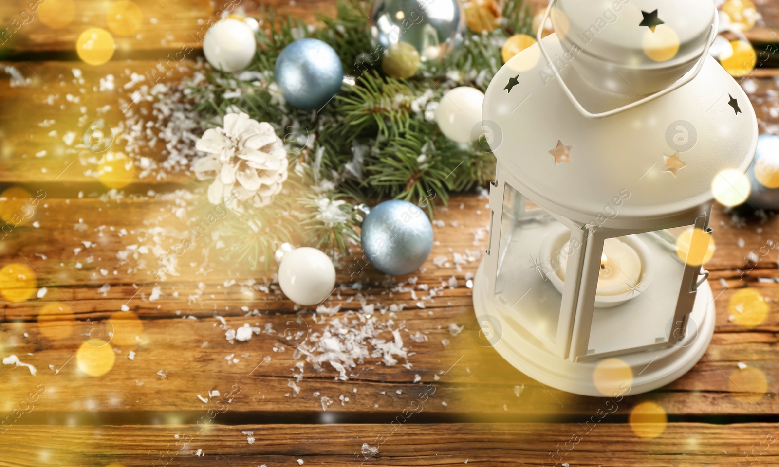 Image of Christmas lantern with burning candle and festive decor on wooden table