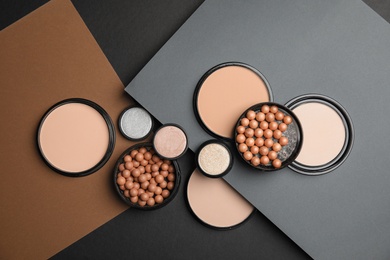 Photo of Flat lay composition with various makeup face powders on color background