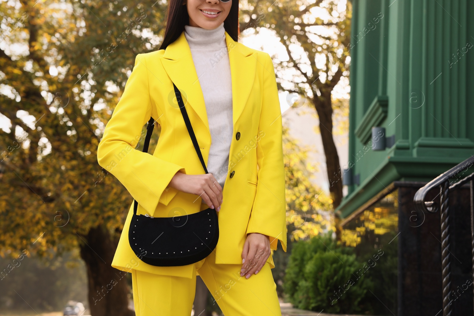 Photo of Fashionable young woman with stylish bag on city street, closeup. Space for text