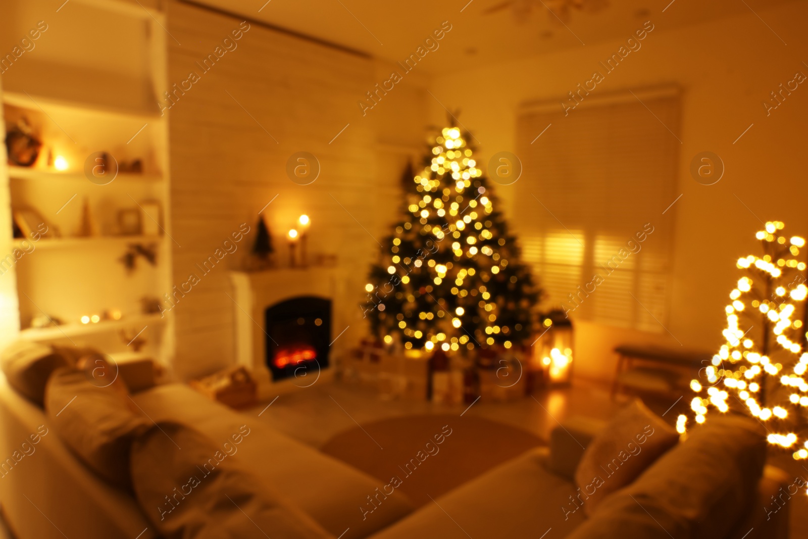 Photo of Blurred view of festively decorated living room with Christmas tree near fireplace