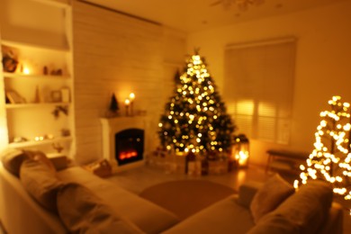 Blurred view of festively decorated living room with Christmas tree near fireplace