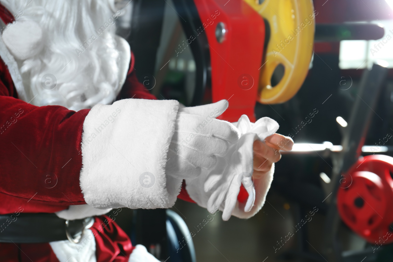 Photo of Authentic Santa Claus wearing gloves  in modern gym, closeup