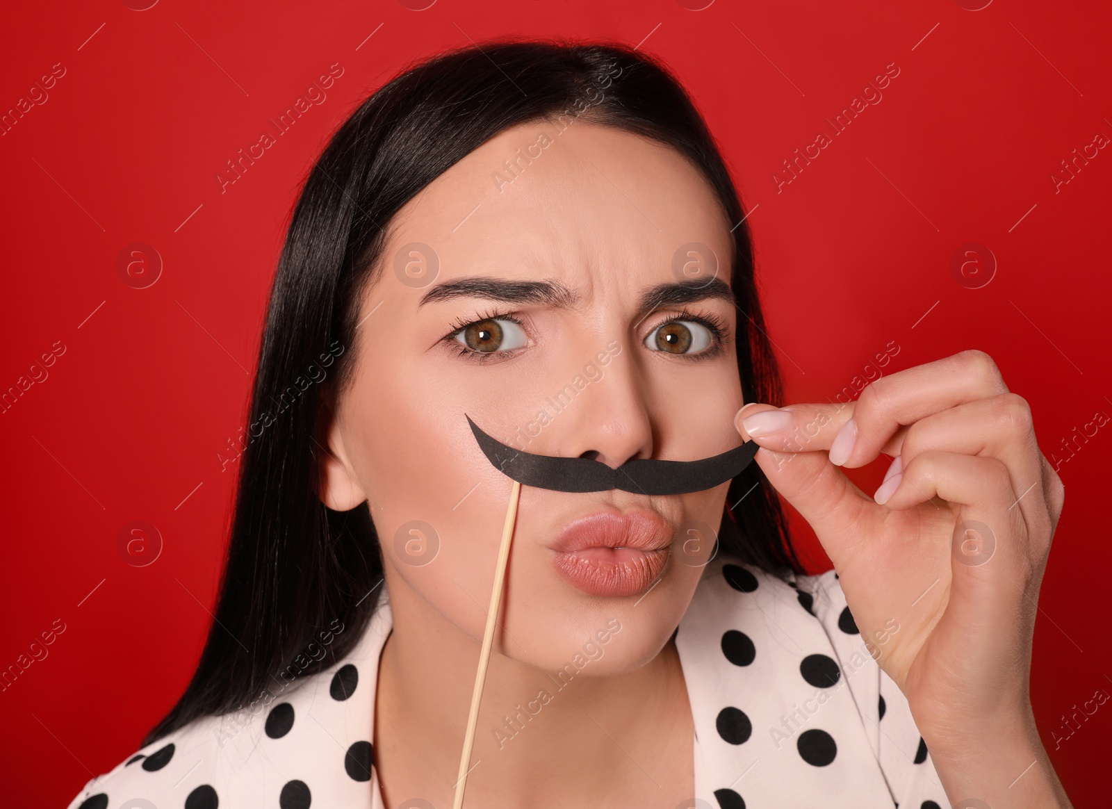 Photo of Funny woman with fake mustache on red background