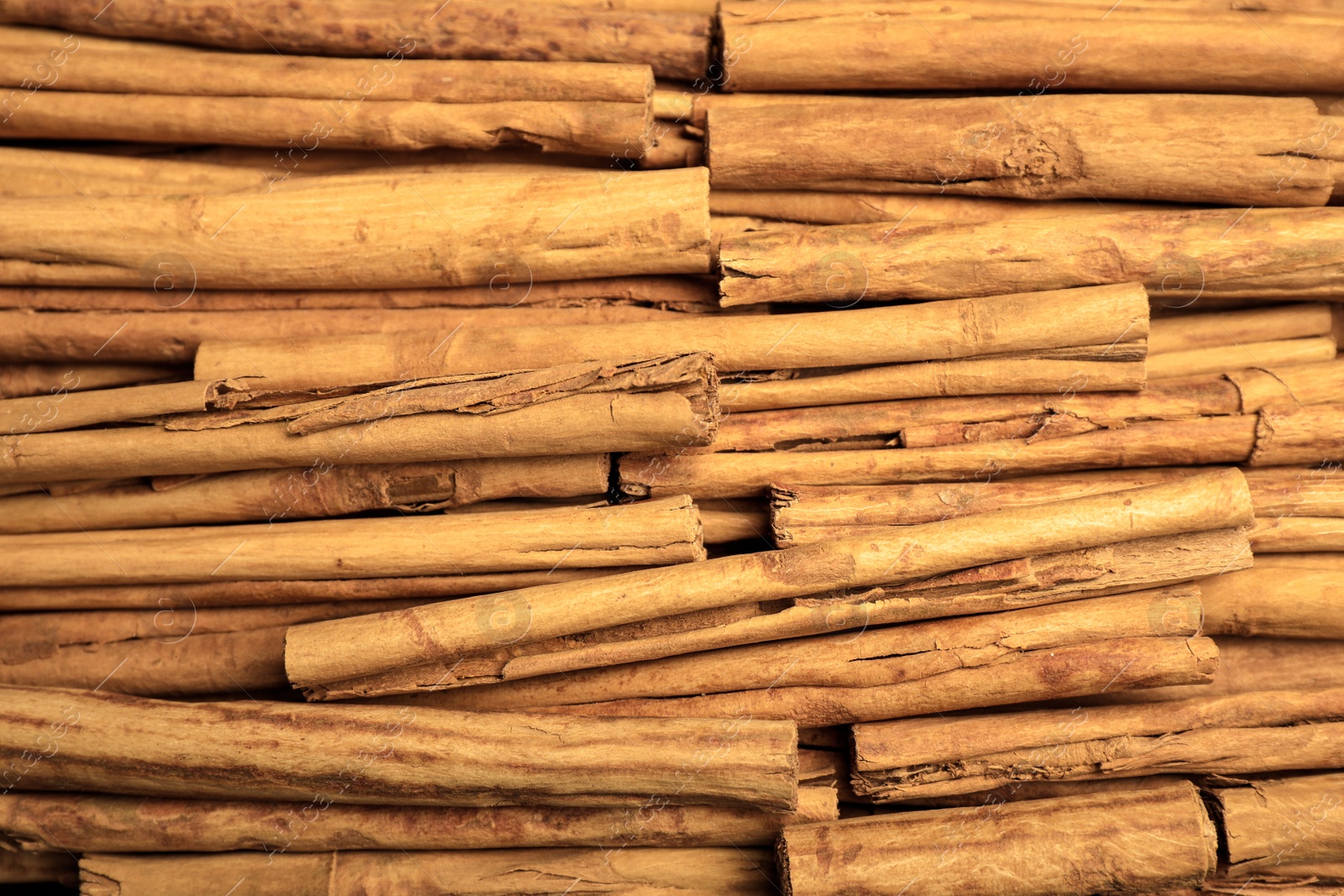 Photo of Aromatic dry cinnamon sticks as background, closeup