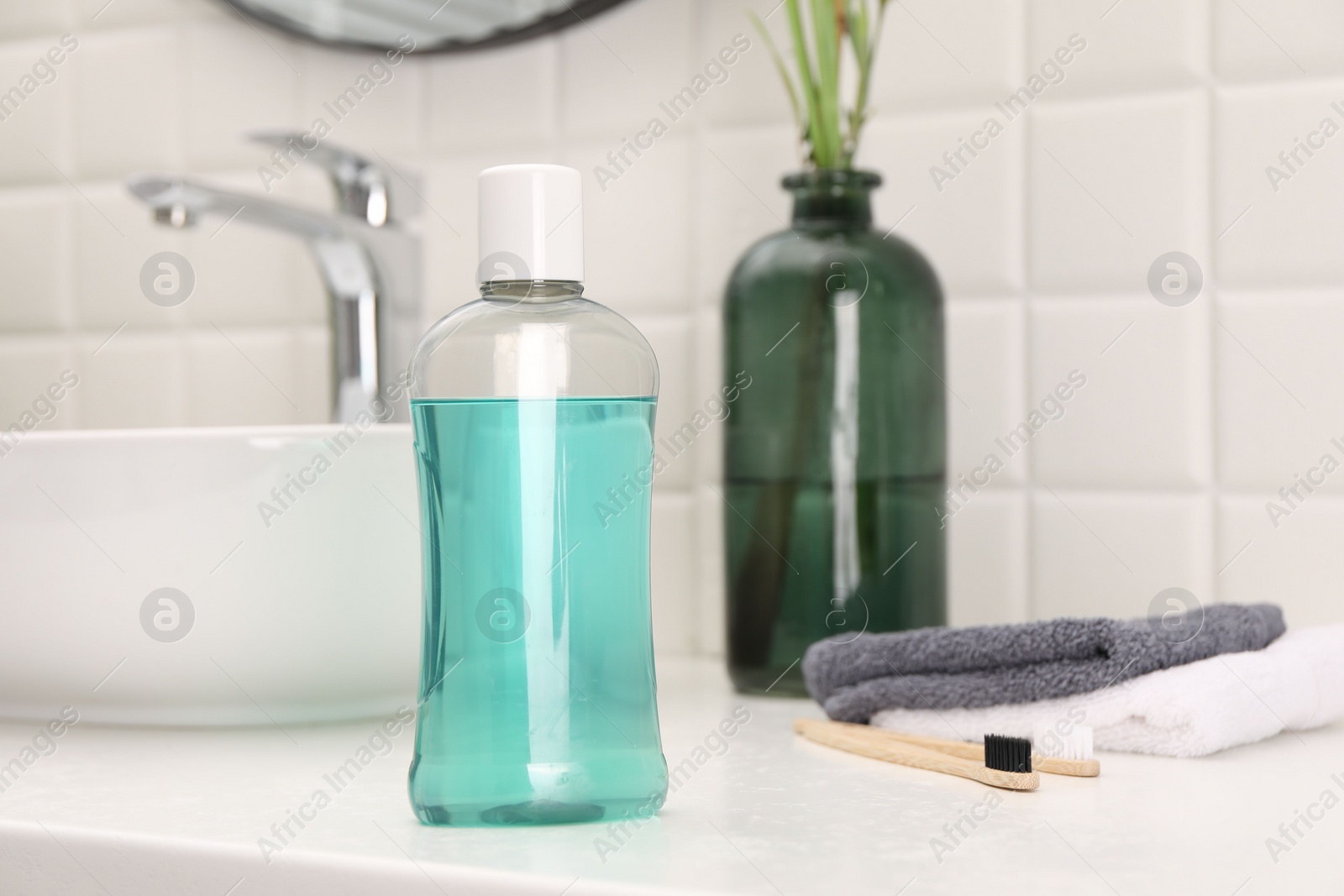 Photo of Bottle of mouthwash on white table in bathroom