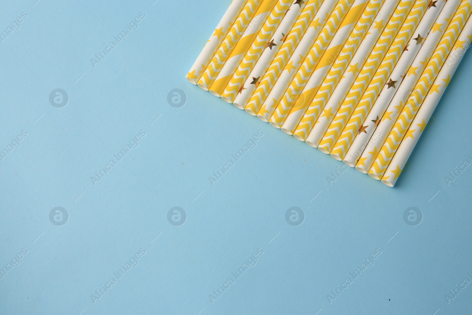Photo of Many paper drinking straws on light blue background, flat lay. Space for text