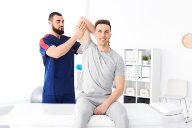 Physiotherapist working with young male patient in clinic