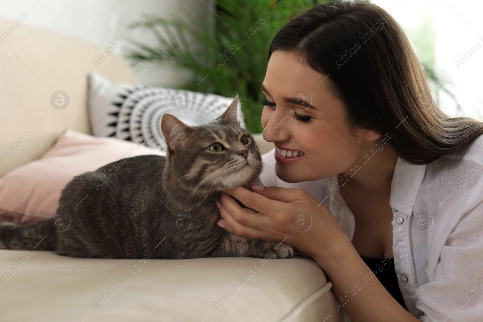 Photo of Young woman with cute cat at home. Pet and owner