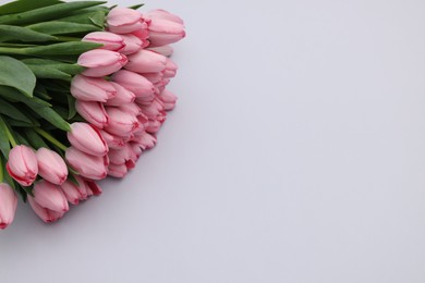 Photo of Bouquet of beautiful pink tulips on light grey background, above view. Space for text