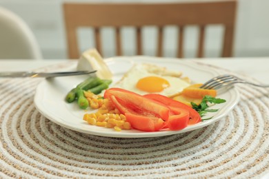 Photo of Delicious breakfast with fried egg and vegetables served on table indoors, closeup