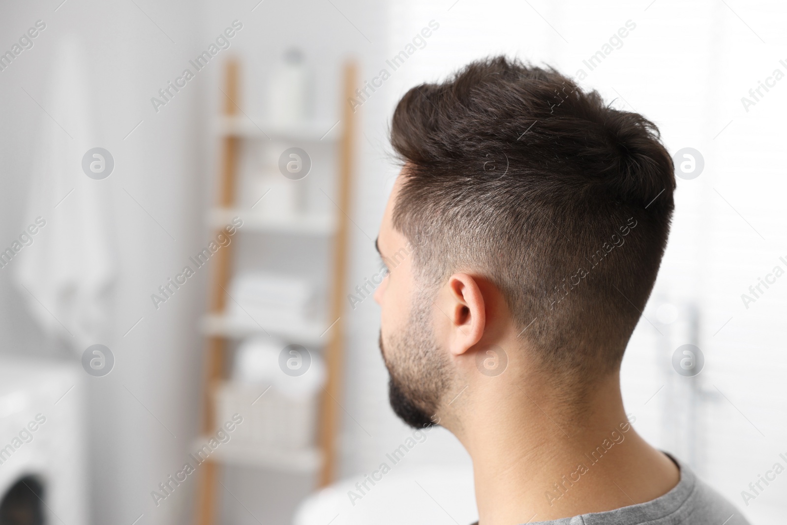 Photo of Man with healthy hair in bathroom, space for text