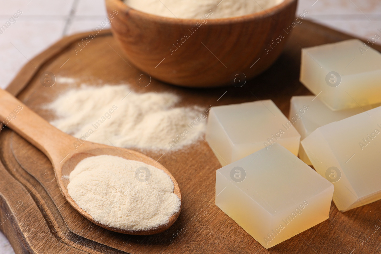 Photo of Agar-agar jelly cubes and powder on wooden board, closeup